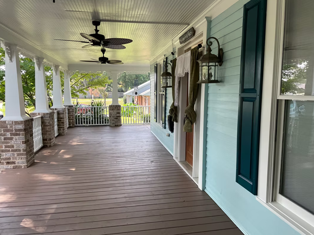 A beautifully painted Alpharetta home porch featuring fresh light blue exterior siding, contrasting dark teal shutters, and crisp white trim showcasing the impact of professional exterior painting.