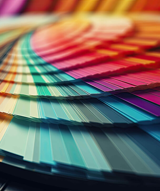 A close-up of a fanned-out color swatch booklet displaying a spectrum from cool blues to warm reds, capturing a vibrant and dynamic array of hues.