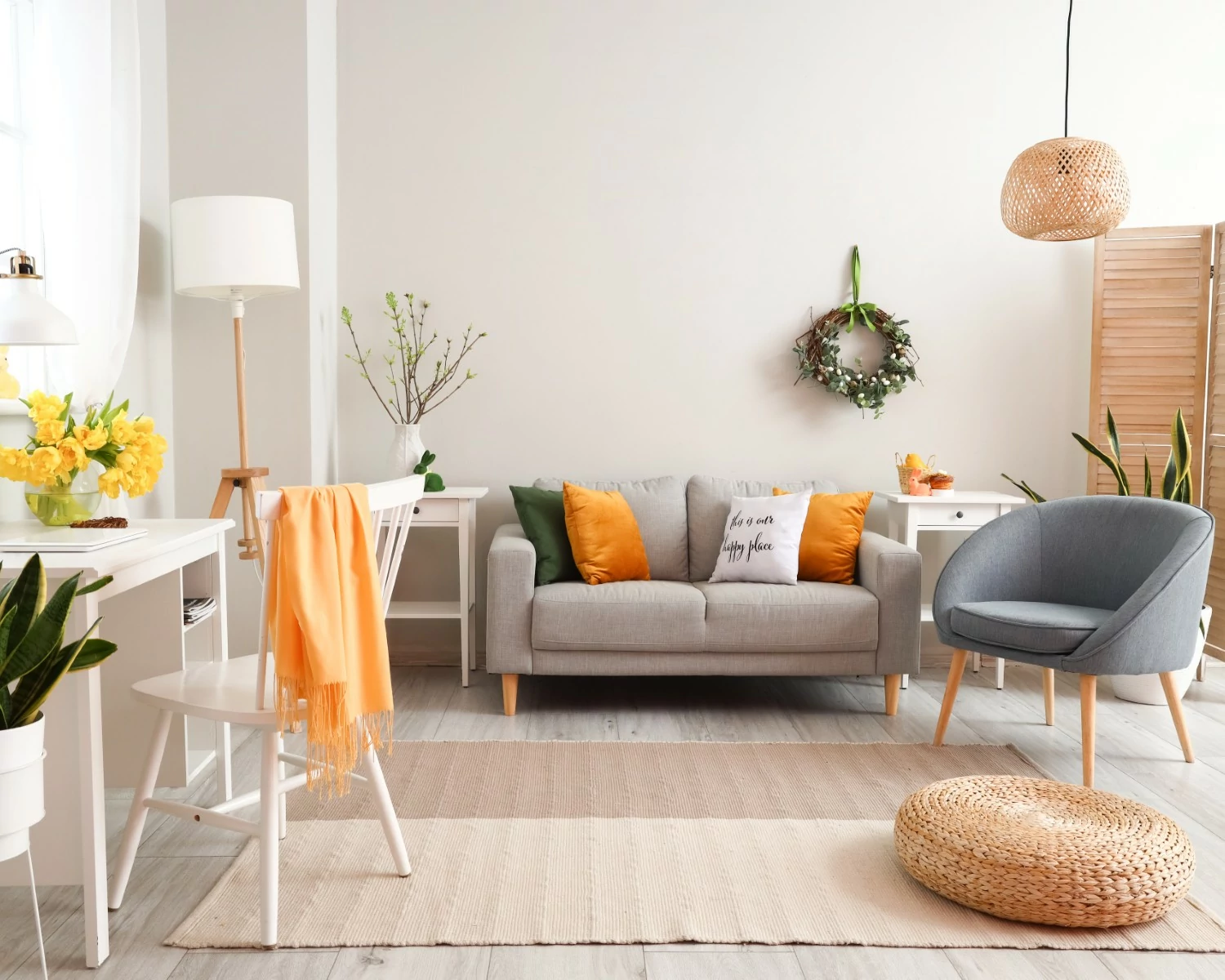 Bright, cozy living room with a gray sofa, yellow and green pillows, and a light blue chair. A woven rug and decor add a warm, inviting feel.